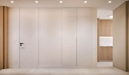 Wnętrze przedpokoju w stylu japandi, minimalistycznym i nowoczesnym z białymi i drewnianymi elementami.