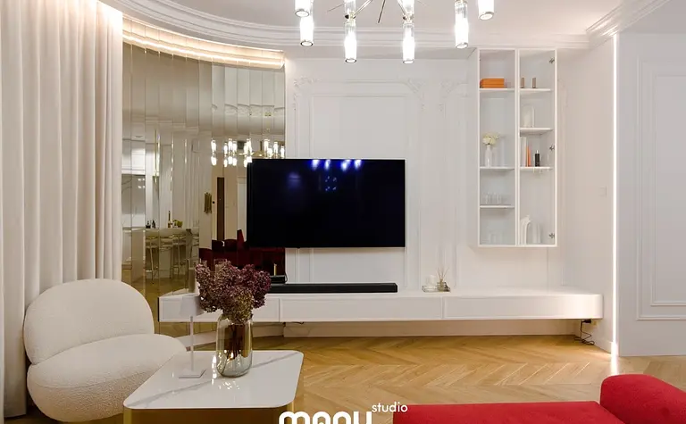 Wnętrze salonu z białymi meblami, nowoczesnymi akcentami i tradycyjnym oświetleniem.