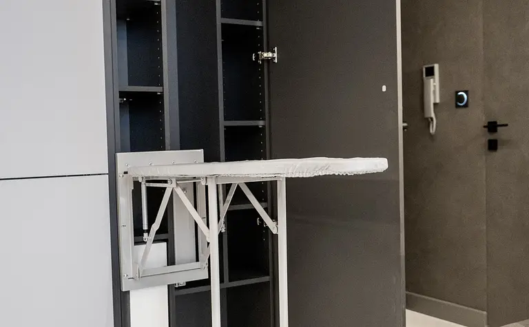 Nowoczesne wnętrze z szarymi meblami i składanym stołem, idealne do małych przestrzeni.