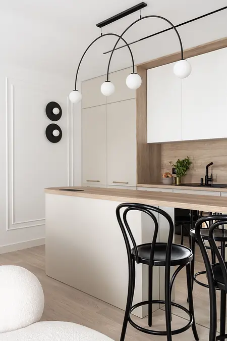 Współczesna kuchnia z białymi meblami i drewnianymi akcentami.