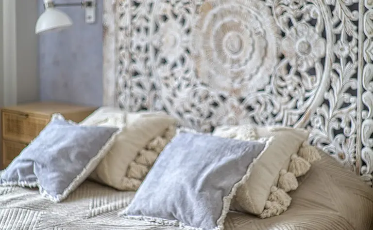 Sypialnia w stylach boho, japandi i vintage z dekoracyjnym zagłówkiem.