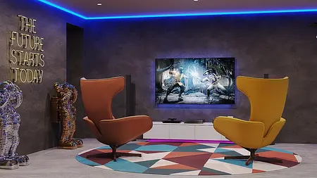 Wnętrze współczesnego pokoju z telewizorem, kolorowymi fotelami i dywanem.