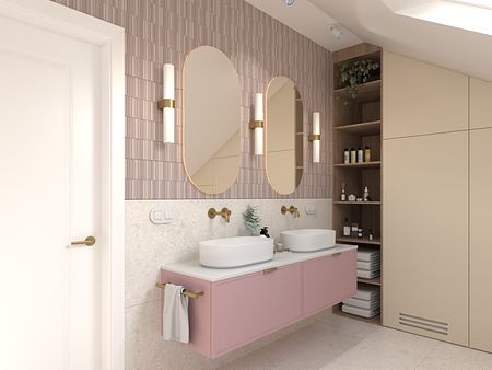 Nowoczesna łazienka z różowym blatem, okrągłymi lustrami i minimalistycznym designem.
