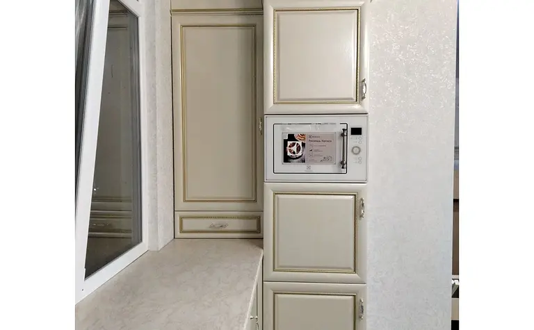 Kuchnia w stylu quiet luxury z beżowymi meblami i nowoczesnym wyposażeniem.