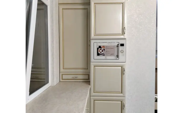 Kuchnia w stylu quiet luxury z beżowymi meblami i nowoczesnym wyposażeniem.
