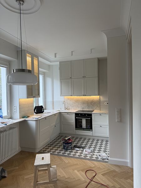 Jasna kuchnia modern retro z kamiennym blatem w mieszkaniu w kamienicy