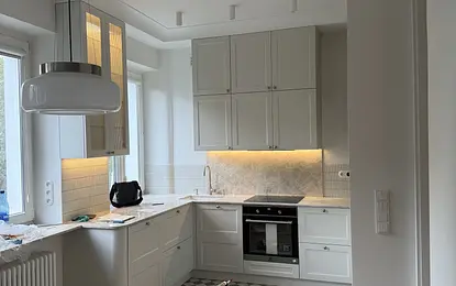 Jasna kuchnia modern retro z kamiennym blatem w mieszkaniu w kamienicy