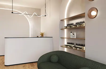 Recepcja z białym blatem, zieloną sofą i półkami w stylu boho i japandi.