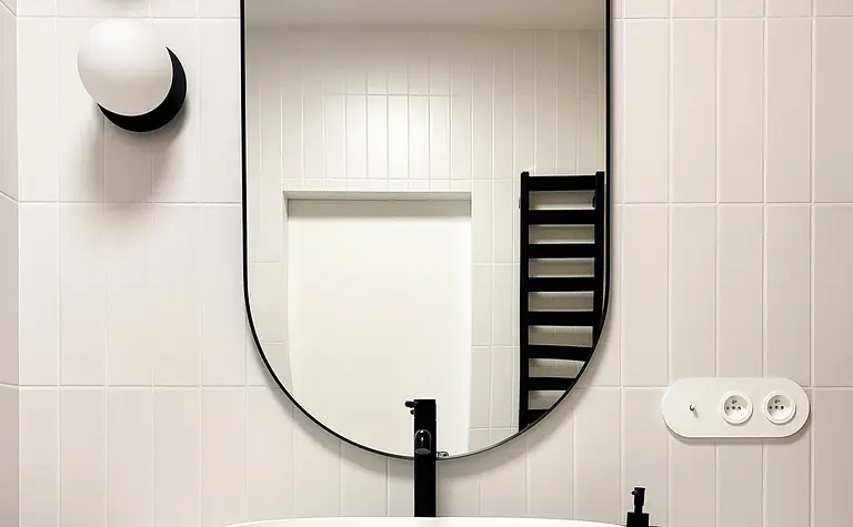 Minimalistyczna łazienka w stylu soft minimalizm z białą umywalką i drewnianymi akcentami.