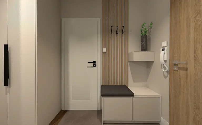 Przedpokój z białą szafą, drewnianymi detalami i rośliną.