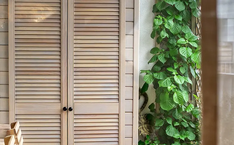 Balkon w stylu boho z drewnianymi meblami i roślinnością
