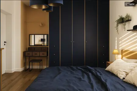 Sypialnia z granatową szafą, beżowym łóżkiem i drewnianymi akcentami w stylu dopamine decor.