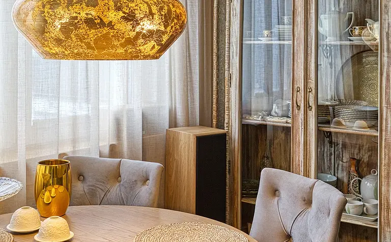 Jadalnia w stylu boho, eklektycznym i rustykalnym z okrągłym stołem i lampą.