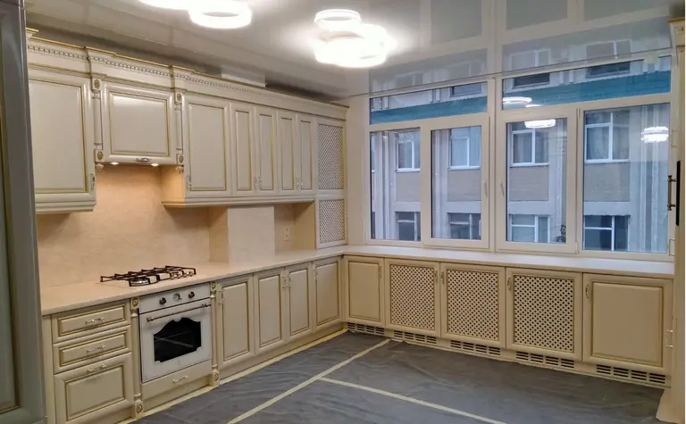 Kuchnia z beżowymi meblami i nowoczesnym oświetleniem, w stylu quiet luxury.