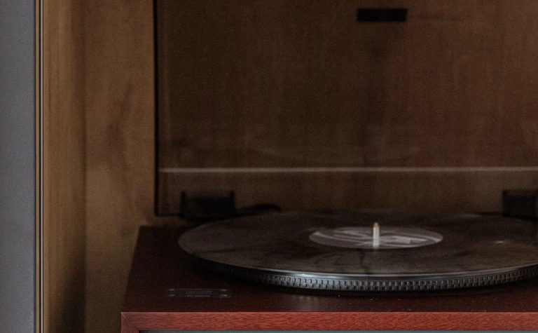 Gramofon TEAC na drewnianej półce w minimalistycznym, nowoczesnym wnętrzu.