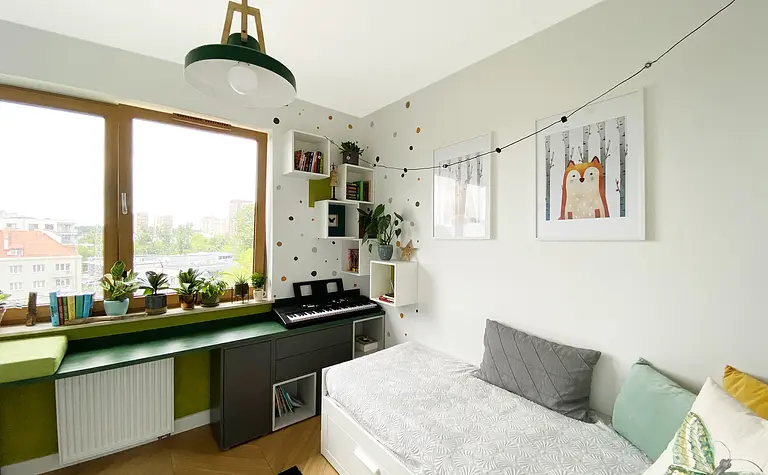 Pokój dziecięcy z zielonymi dodatkami, minimalistyczny wystrój, nowoczesne meble.