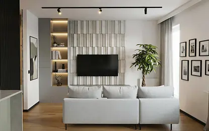 Wnętrze salonu z szarym narożnikiem, drewnianą podłogą i rośliną – styl industrialny i minimalistyczny.