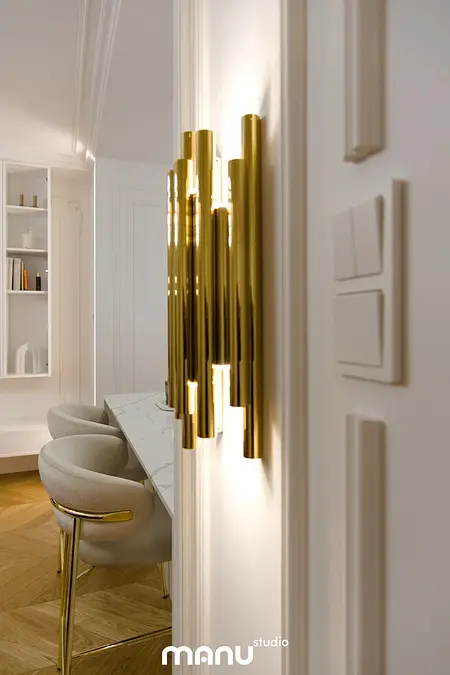 Złote oświetlenie w nowoczesnym wnętrzu z białymi meblami. Styl quiet luxury i tradycyjny.