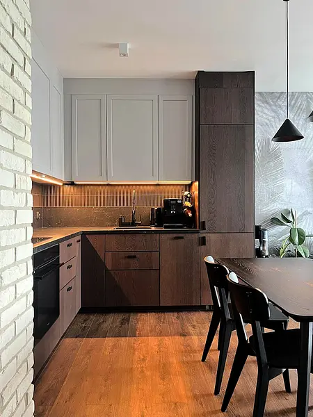 Nowoczesna kuchnia z minimalistycznym designem, ciemnymi meblami i drewnianym wykończeniem.
