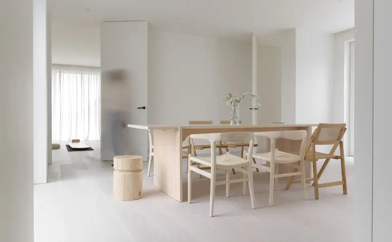 Wnętrze jadalni w stylu minimalistycznym, z drewnianym stołem i białymi krzesłami