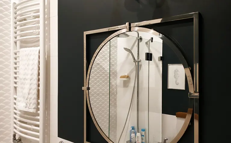 Nowoczesna łazienka z dużym lustrem, czarną ścianą i eleganckim oświetleniem. Styl tradycyjny, współczesny.