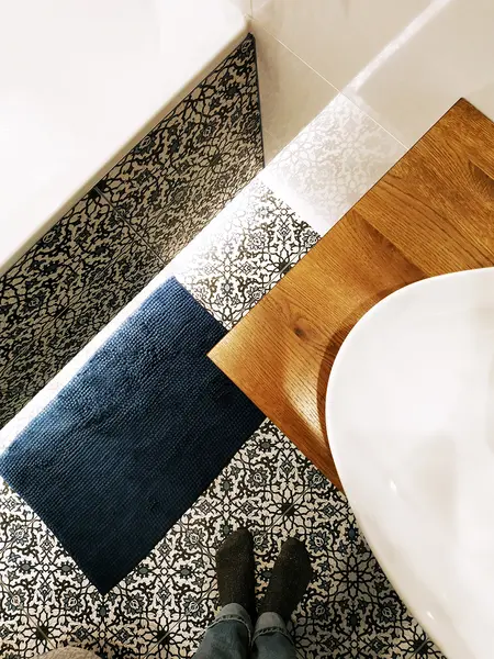 Stylowa łazienka z drewnianym blatem i wzorzystą podłogą, tradycyjny i współczesny design.