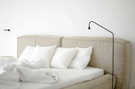 Sypialnia w stylu vintage i współczesnym z czerwoną kanapą i lustrami.