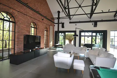 Wnętrze salonu w stylu współczesnym i minimalistycznym z dużymi oknami.