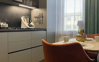 Nowoczesna kuchnia z szarymi meblami i brązowymi detalami, minimalistyczny design.