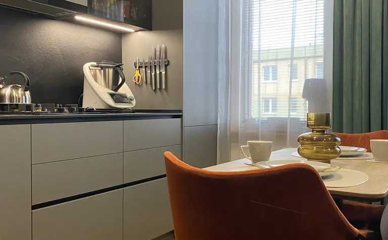 Nowoczesna kuchnia z szarymi meblami i brązowymi detalami, minimalistyczny design.