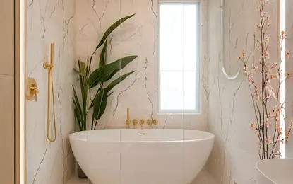 Wnętrze nowoczesnej łazienki z wanną, złotymi detalami oraz roślinnością. Styl boho i japandi.
