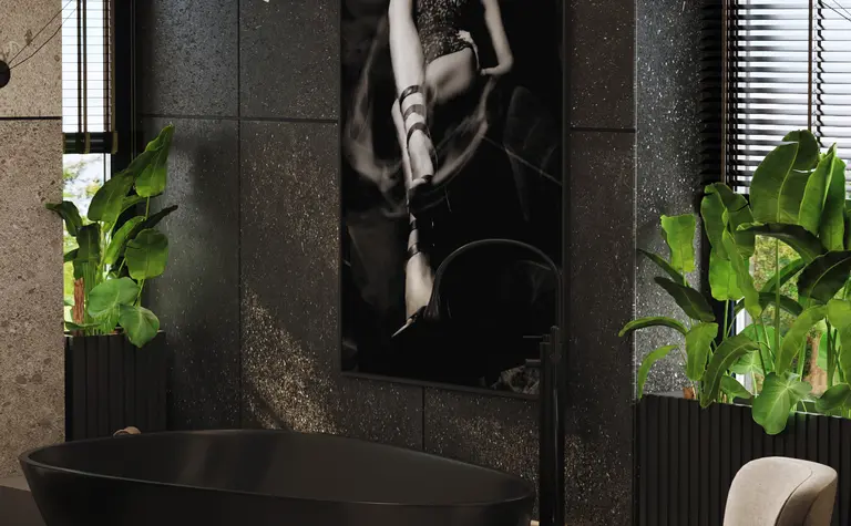 Nowoczesna łazienka z czarną wanną, roślinami i eleganckim fotelem.