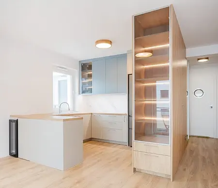 Nowoczesna kuchnia z niebieskimi meblami i drewnianym blatem, minimalistyczny design.