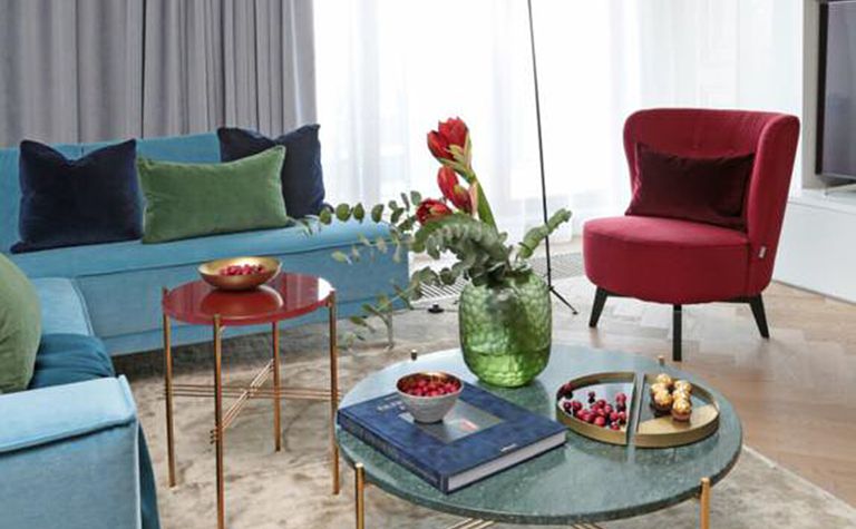 Wnętrze salonu w stylu minimaluxe i quiet luxury z niebieską sofą.
