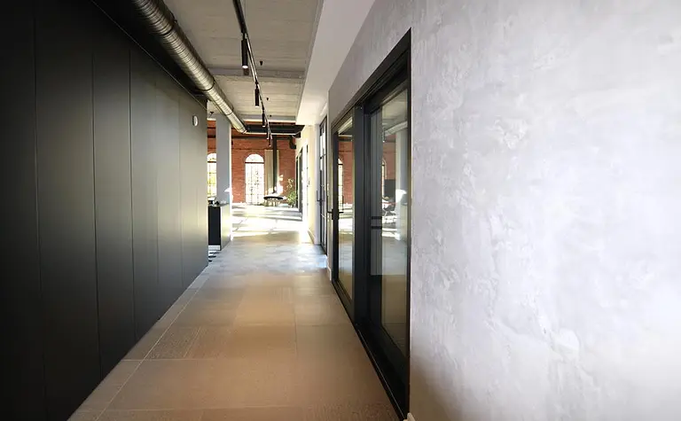 Wnętrze korytarza w stylu industrialnym, minimalistycznym z szarymi i czarnymi akcentami.