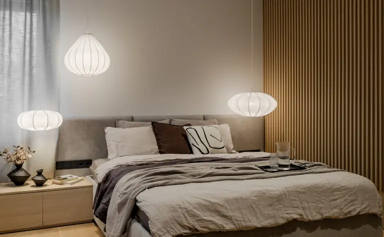 Wnętrze sypialni w stylu japandi i minimalistycznym z białymi lampami.