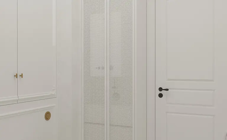 Wnętrze łazienki z białymi meblami, podłogą art deco oraz tradycyjnymi detalami.