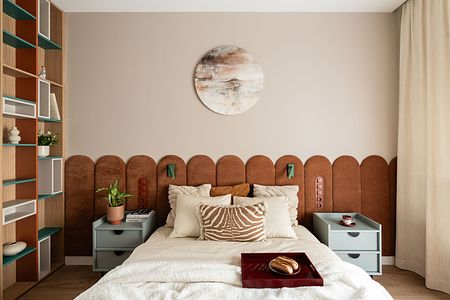 Wnętrze sypialni z brązowym wezgłowiem, zielonymi akcentami i nowoczesnym wystrojem.