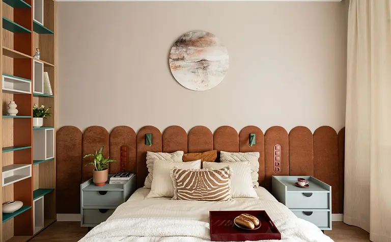 Wnętrze sypialni z brązowym wezgłowiem, zielonymi akcentami i nowoczesnym wystrojem.