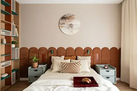 Wnętrze sypialni z brązowym wezgłowiem, zielonymi akcentami i nowoczesnym wystrojem.