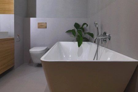 Nowoczesna łazienka boho z wanną, rośliną i minimalistycznymi detalami.