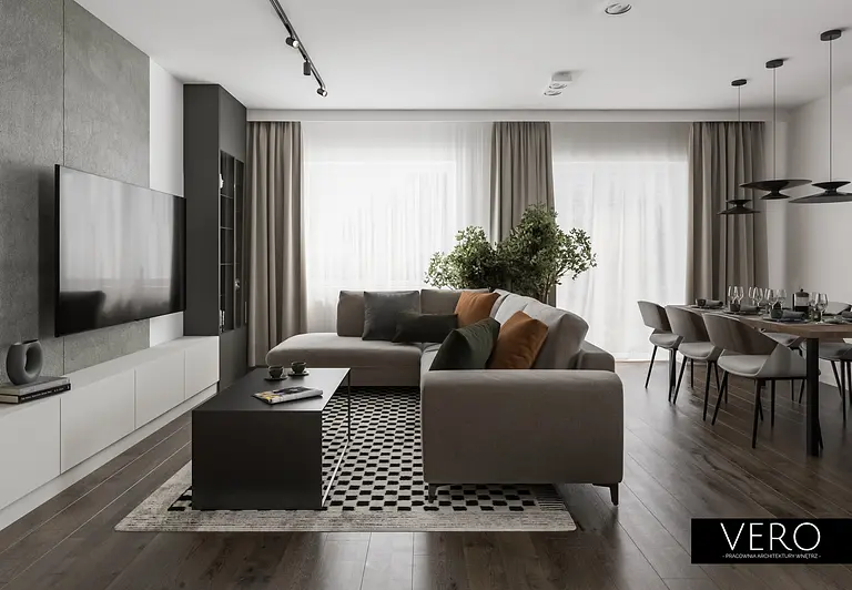 Wnętrze nowoczesnego salonu z minimalistycznym designem, szarymi meblami i zielonymi roślinami.