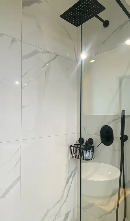 Nowoczesna łazienka z minimalistycznym prysznicem, skandynawskimi akcentami i quiet luxury.