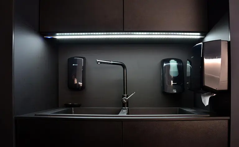 Kuchnia minimalistyczna z czarnym zlewem i nowoczesnymi akcesoriami