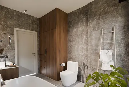 Wnętrze łazienki w stylu nowoczesnym z drewnianymi meblami i szarymi ścianami.