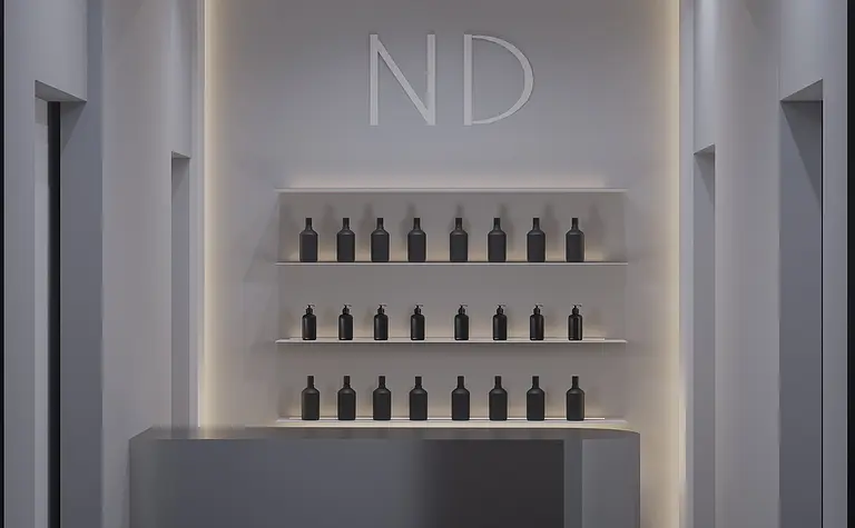 Wnętrze nowoczesnej recepcji z minimalistycznym designem, szarym blatem i czarnymi butelkami.