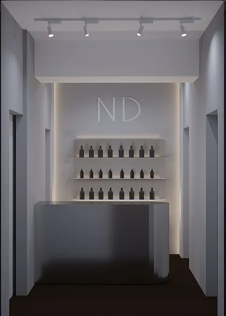 Wnętrze nowoczesnej recepcji z minimalistycznym designem, szarym blatem i czarnymi butelkami.