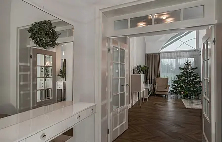 Przedpokój z białymi meblami, drewnianą podłogą i choinką. Styl nowoczesny, quiet luxury, tradycyjny.