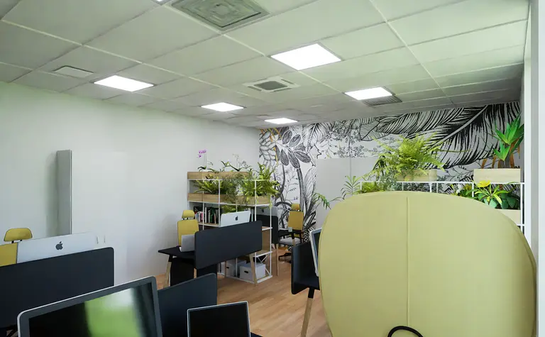 Biuro z nowoczesnym wystrojem, roślinami i ergonomicznie zaprojektowanymi biurkami.