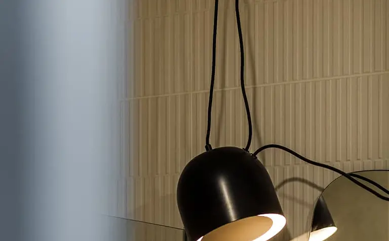 Wnętrze łazienki z lampą w stylu japandi, vintage i współczesnym. Jasne płytki.